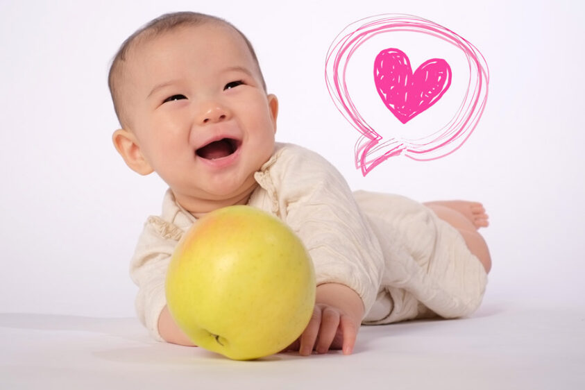 りんご持って笑顔の赤ちゃん