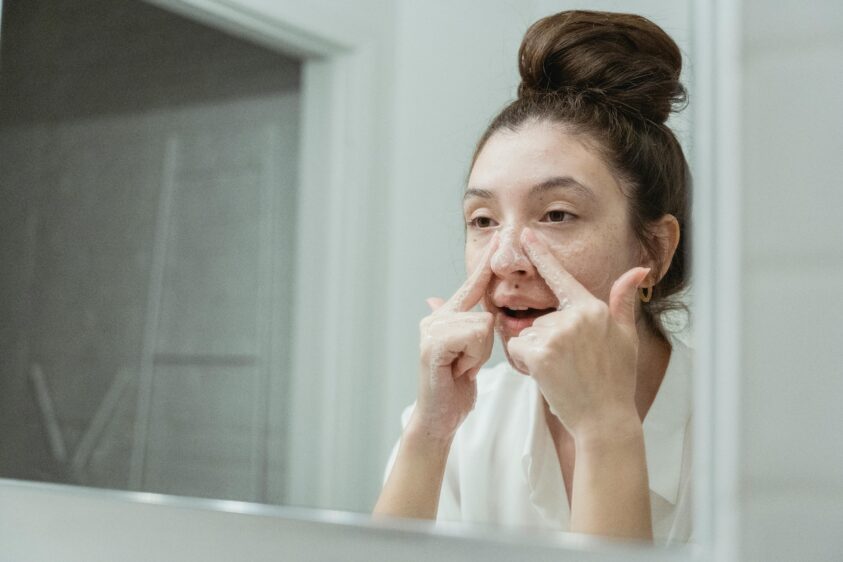鏡を見ながら洗顔をしている女性