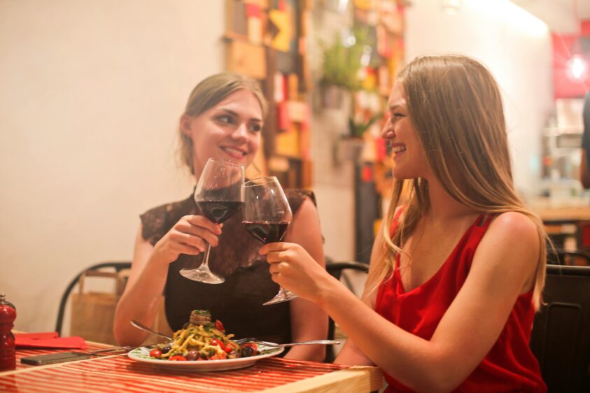 食事中にワインで乾杯する2人の女性